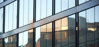 Stick vs Unitized Curtain Walls shown on a modern glass building façade.