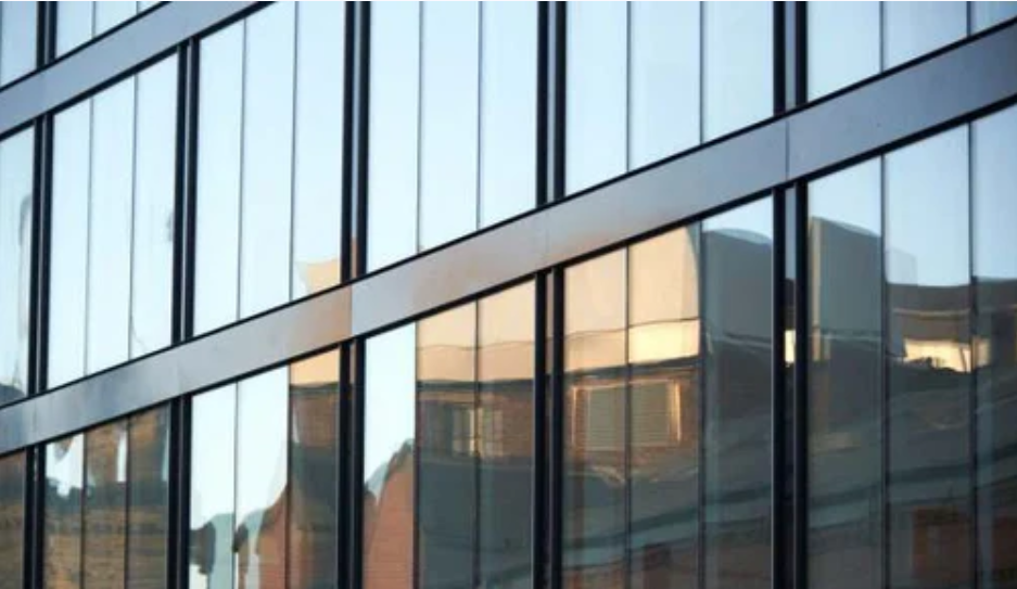 Stick vs Unitized Curtain Walls: A Comprehensive Guide for Modern Architecture in Pakistan Stick vs Unitized Curtain Walls shown on a modern glass building façade.
