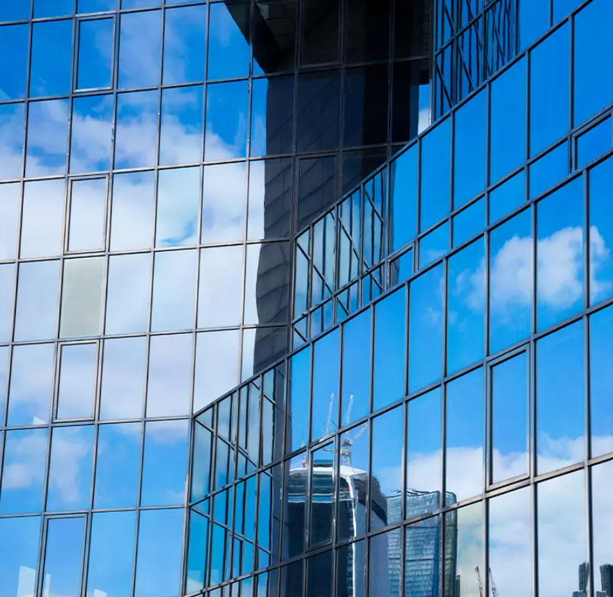 Stick vs Unitized Curtain Walls: A Comprehensive Guide for Modern Architecture in Pakistan Stick vs Unitized Curtain Walls featured on a sleek, modern glass building.