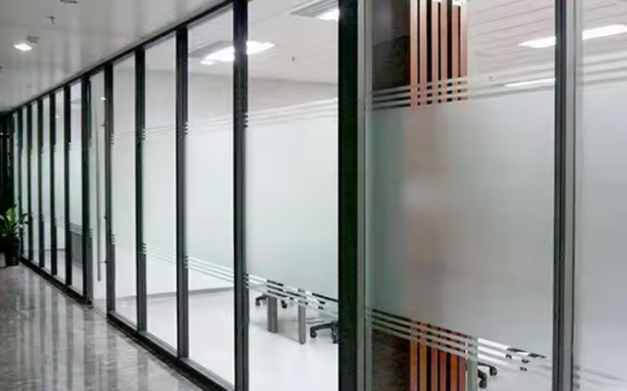 Sleek frameless soundproof glass partition creating quiet meeting pods in a modern Pakistani office