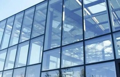 Frameless glass façade using point glass fixing systems in modern architectural design.
