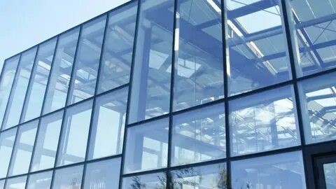 Frameless glass façade using point glass fixing systems in modern architectural design.